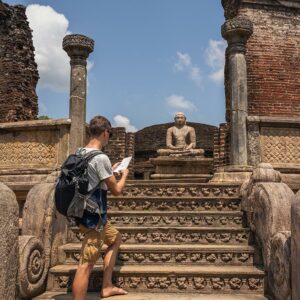 A Foreigner climbing up the stairs at the Sacred Quadrangle at the Ancient City of Polonnaruwa