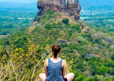 A foreign lady sitting on the Pidurangala rock top, witnessing the view of the Sigiriya Rock Fortress