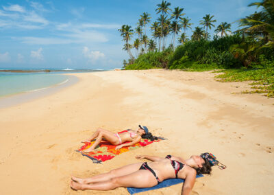 Two Women Sunbathing on a Beach in Sri Lanka