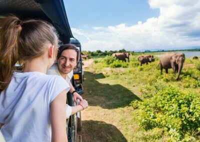 A father and daughter observing the elephants of Udawalwe during a safari ride.