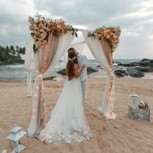A Young Couple in Wedding Attire kissing each other at a Beach Wedding Ceremony at Sri Lanka