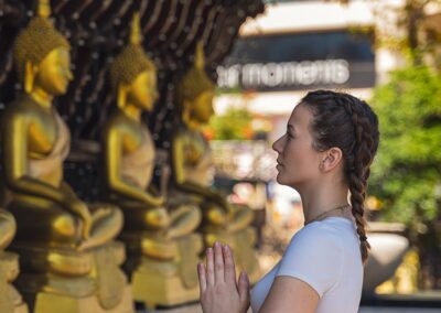 A Foreign Lady Worshipping the golden Buddha statues at Gangaramaya Temple