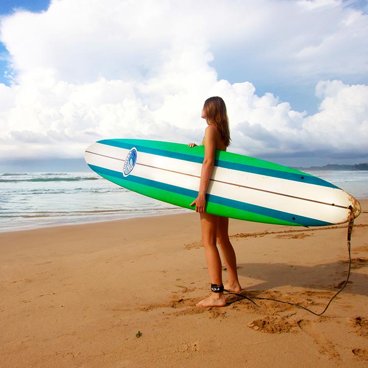 A Foreign girl with a surfboard at the Weligama Beach