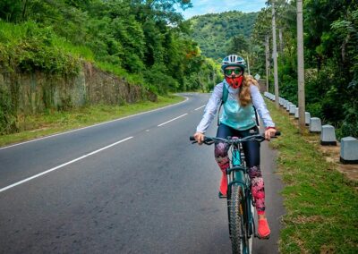 A foreign girl in cycling clothes riding a bicycle on a road in Sri Lanka