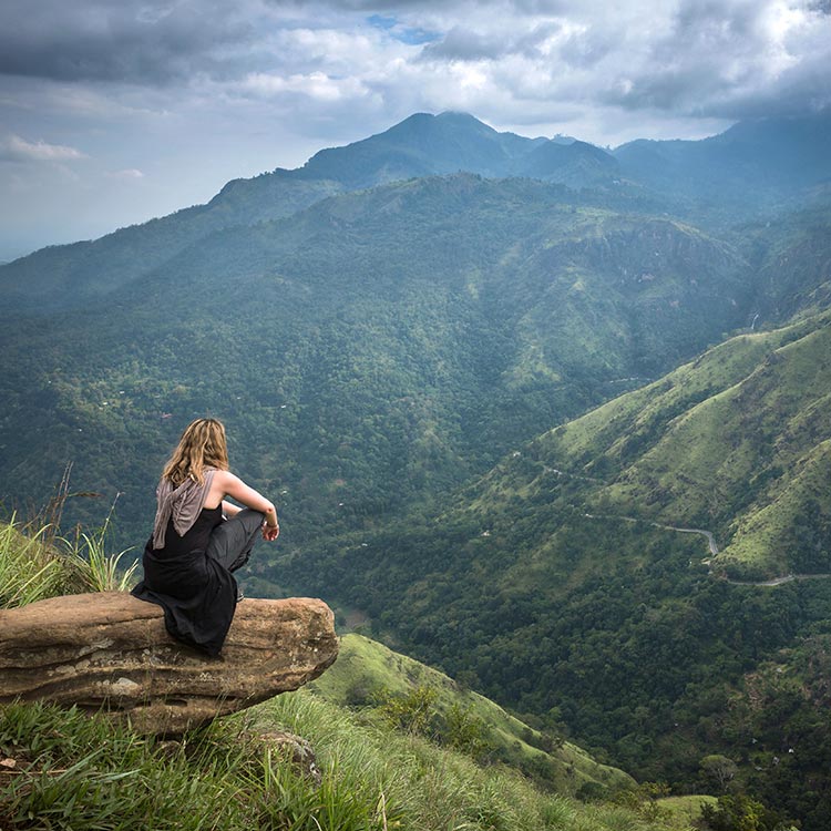 A foreign lady in black sitting on the top of Little Adam's Peak