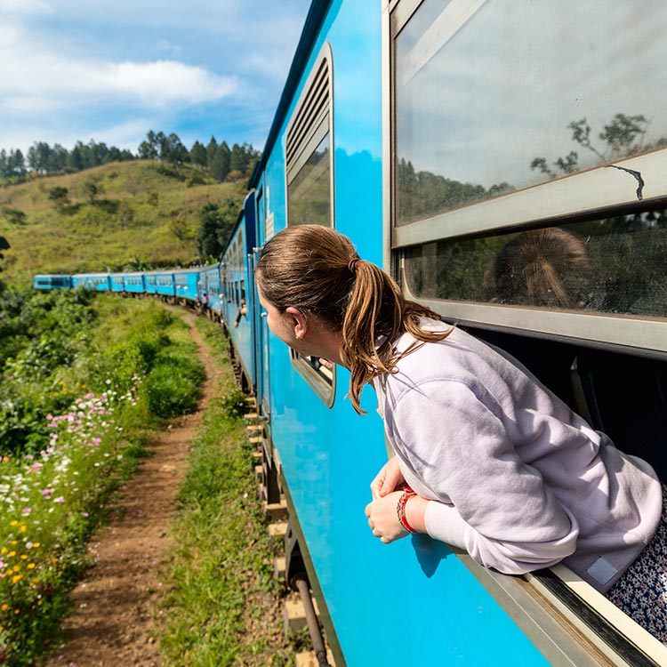 A Young Woman Enjoying the Surrounding while on a Train Ride, Peeping through the window of a train