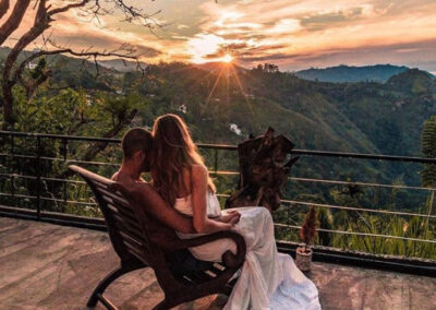 A Couple seated on a balcony, witnessing the beauty of a sunrise. during their honeymoon in Sri Lanka