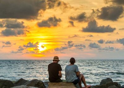 A Couple Sitting on Rocks Enjoying the Sunset at the Shores of Negombo