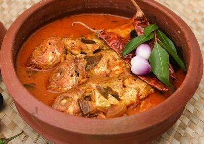 A fish curry in a clay pot, and the spices used to prepare it