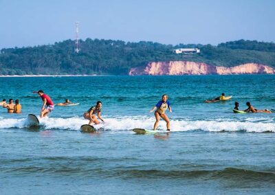 A few people surf on a small wave at Weligama